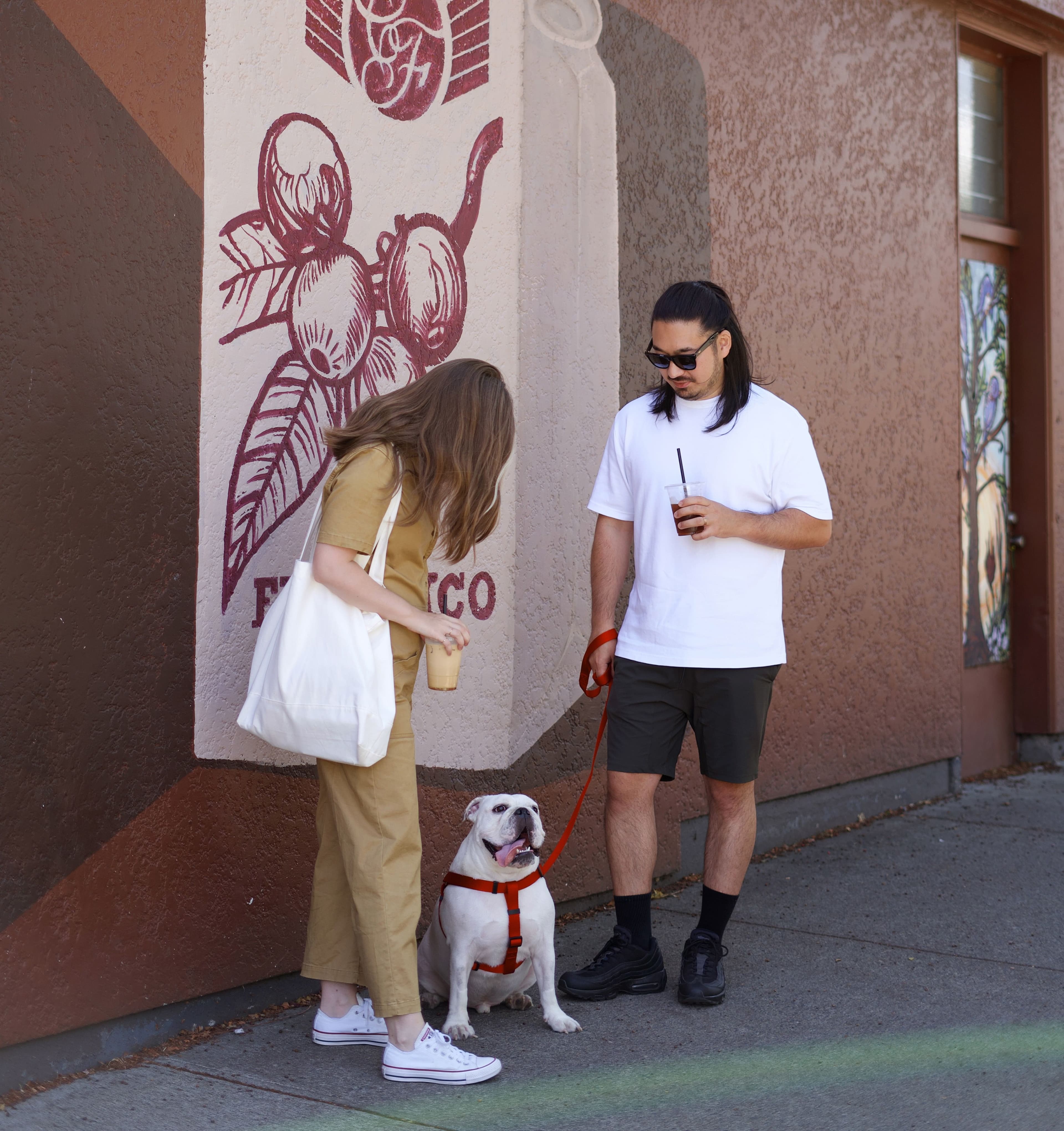 bulldog with couple in front of cafe