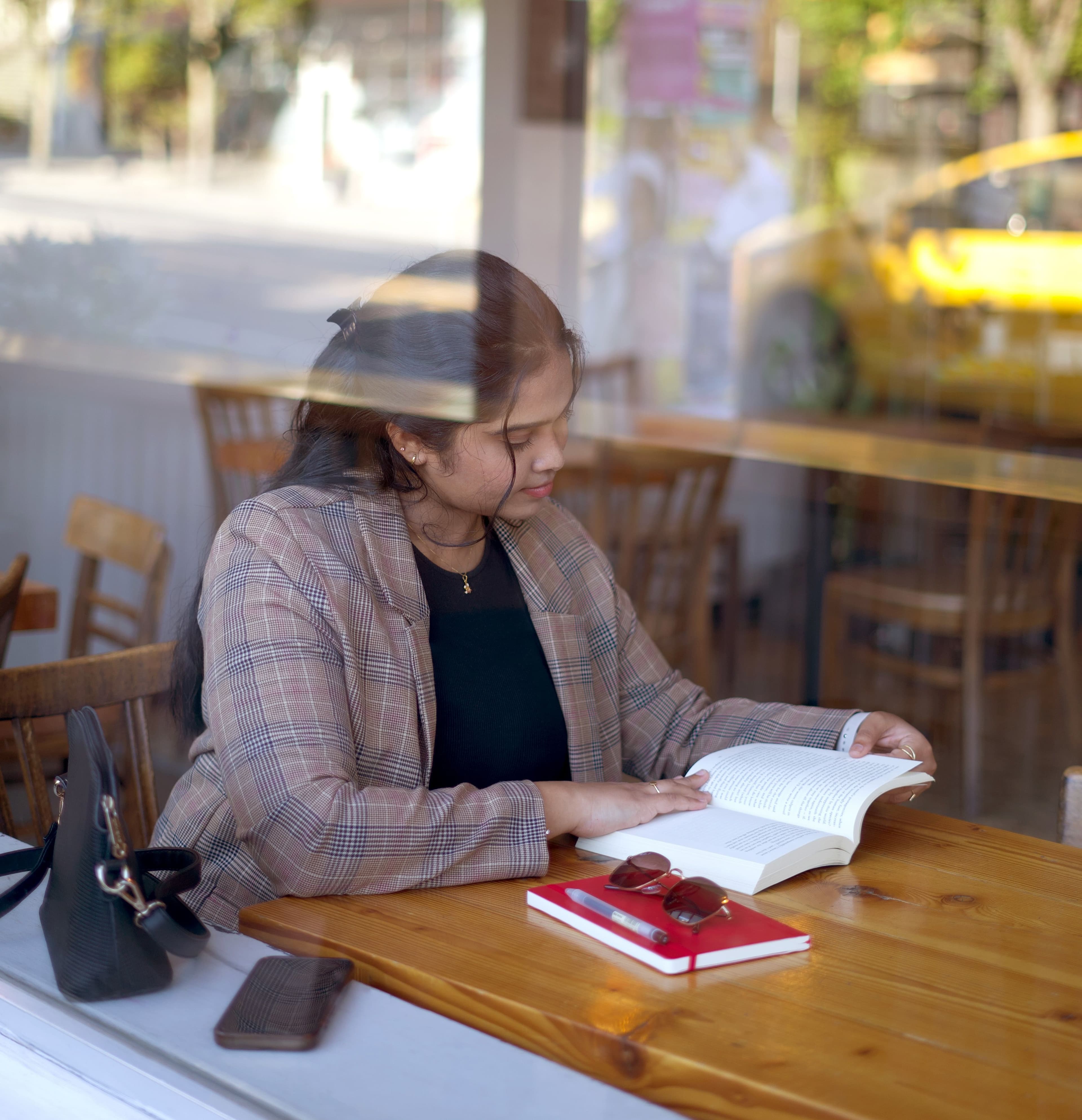 woman reading at table in cafe